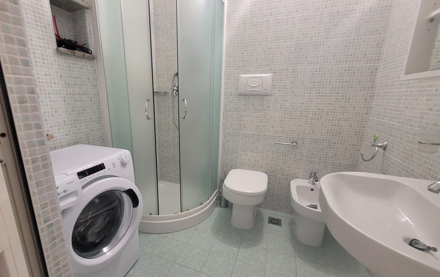 Il bagno con doccia e lavatrice